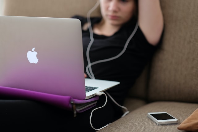 Woman with a MacBook on a sofa