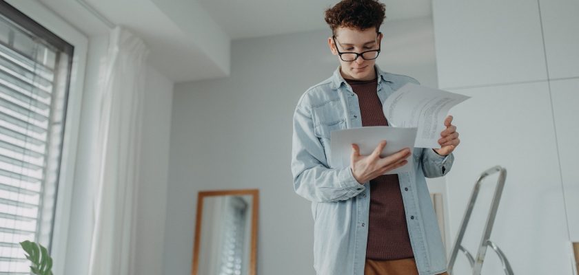 man holding pieces of paper