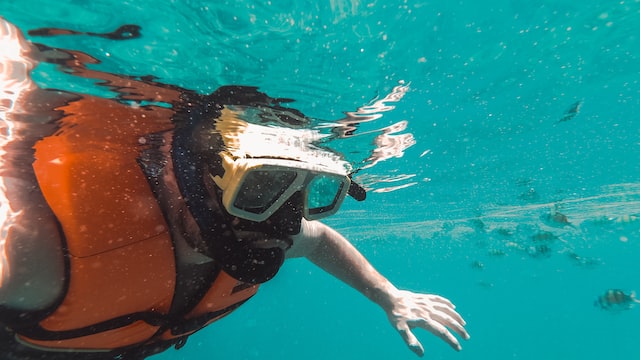 man swims with a mask and snorkel underwater